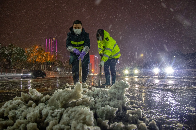 长沙收费站工作人员根除收费广场上的积雪  （周全摄）